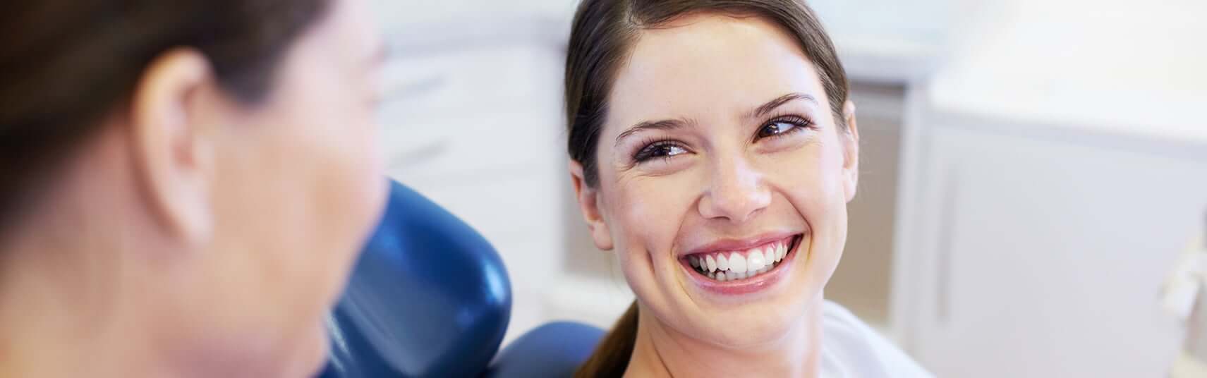 smiling woman talking with her dentist