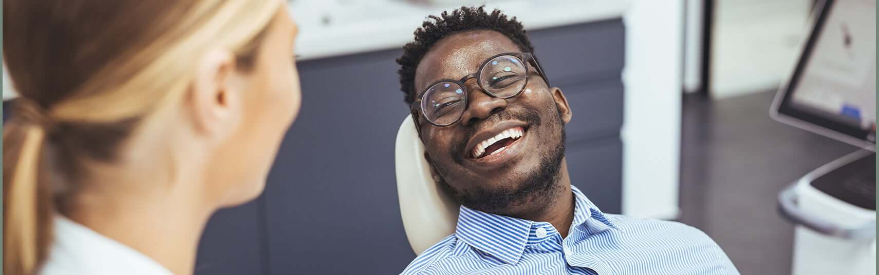 smiling man sitting in a dental chair
