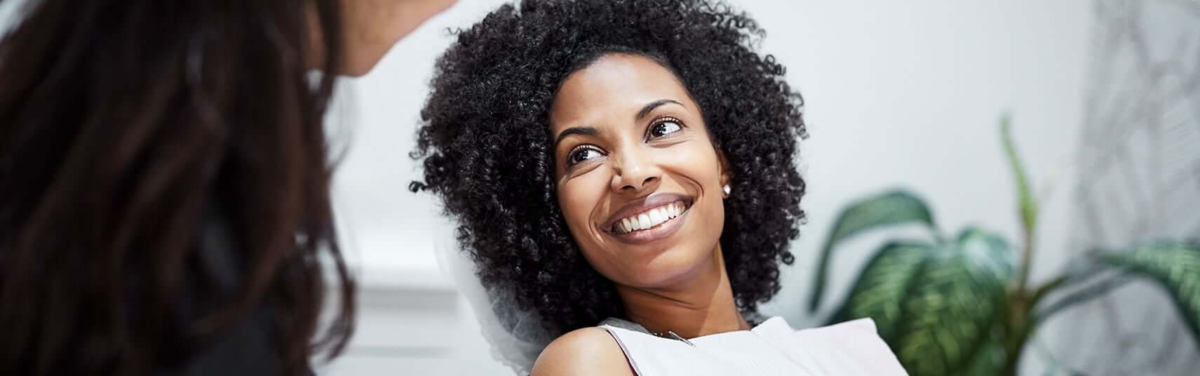 smiling woman talking with her dentist