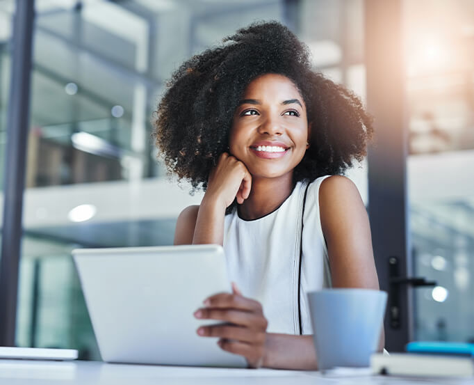 smiling woman sitting in front of a laptop