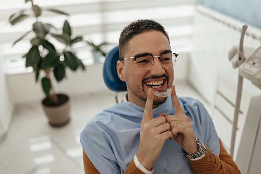 man holding clear aligners, Invisalign can be a holistic way to straighten teeth